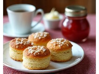 An elegant afternoon tea setting with freshly baked scones, clotted cream, and jam.